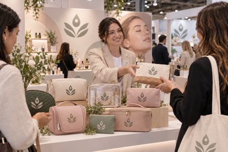 Pochette personalizzate esposte e distribuite a uno stand di cosmetici
